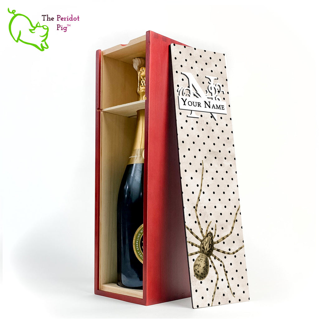 The wine box front panel is decorated in a glossy, detailed print with a white monogram and space for a customized name. This model has a mottled beige background with a pattern of black dots. In the foreground is a large drawing of huge spider. Not for the faint at heart! Cherry version showing the interior and a sample bottle of wine.