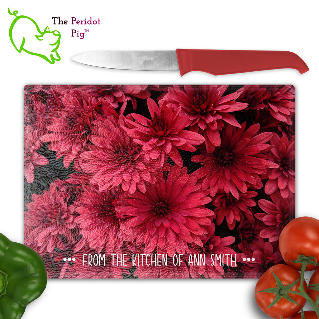 These beautiful tempered glass cutting boards are a wonderful keepsake!  They can be personalized with names, quotes or dates. This one features bright pink dahlias in a vivid and detailed print. Front view show with a personalized name and kitchen cutlery.