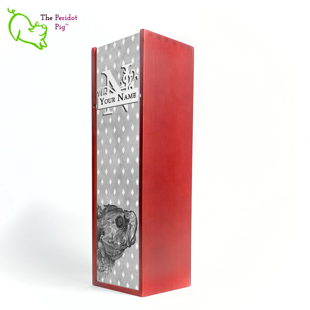 The wine box front panel is decorated in a glossy, detailed print with a white monogram and space for a customized name. This model has a smokey gray background with a pattern of white diamond shapes. In the foreground is a large black line drawing of a fish. Cherry finish showing the front view.