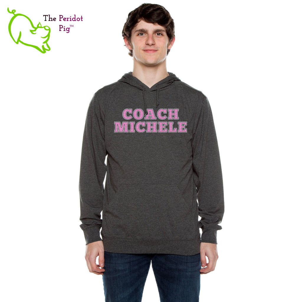 The Coach Michele long sleeve t-shirt hoodie is a light-weight version of your classic pullover hoodie. The front features the text, "Coach Michele" in two colors of glitter vinyl. The back is blank. Front view shown in Charcoal.