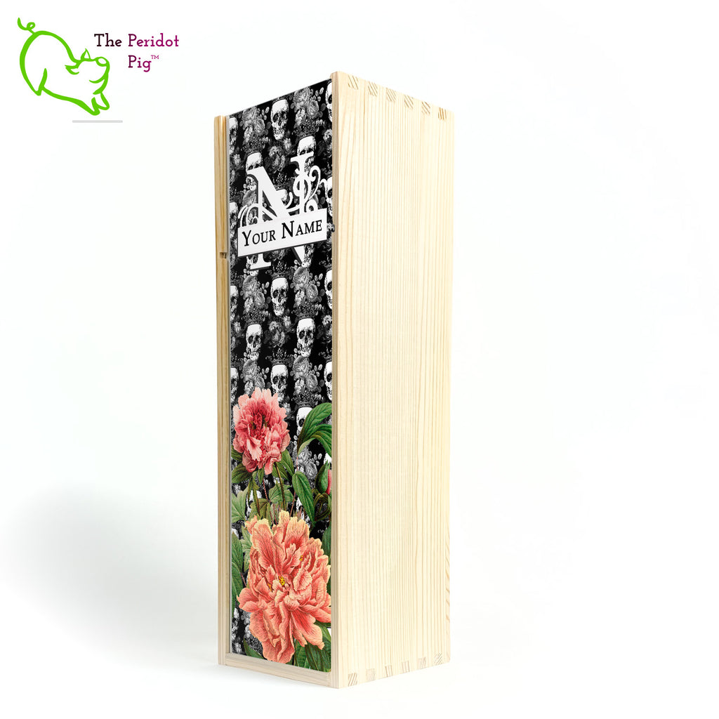 The front panel is decorated in a glossy, detailed print with a monogram and space for a customized name. This model has a background of Victorian skulls wearing a crown. in the foreground, there are two colorful peonies with green foliage. Front view in natural.