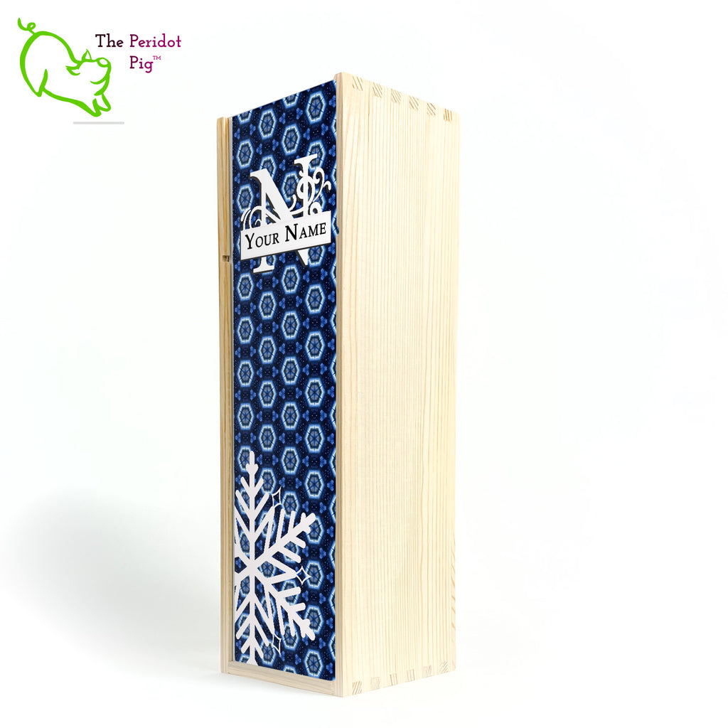 The wine box front panel is decorated in a glossy, detailed print with a white monogram and space for a customized name. This model has a deep blue background with crystalized pattern. In the foreground is a large white snowflake. Shown in natural front view.