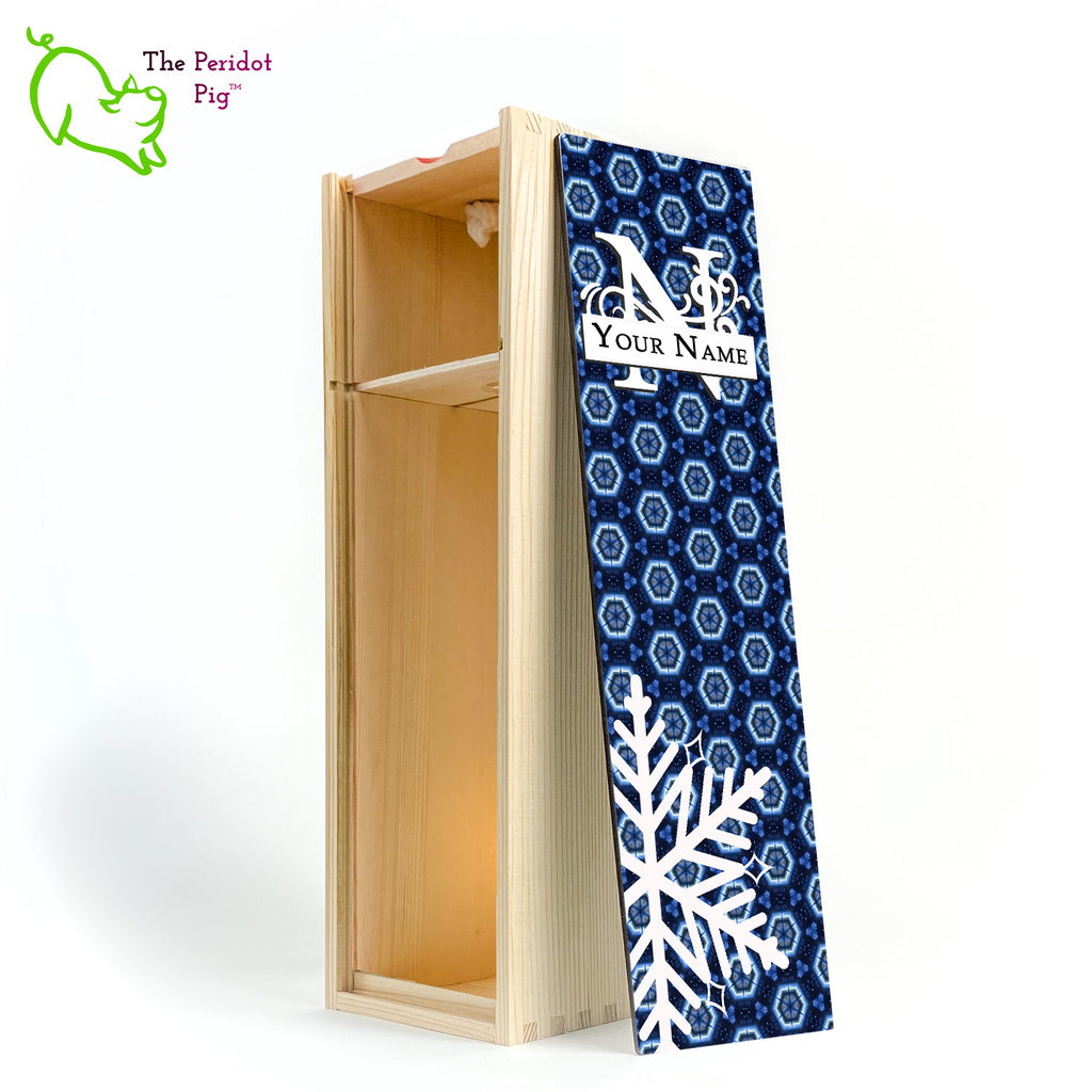 The wine box front panel is decorated in a glossy, detailed print with a white monogram and space for a customized name. This model has a deep blue background with crystalized pattern. In the foreground is a large white snowflake. Shown in natural with an interior view.