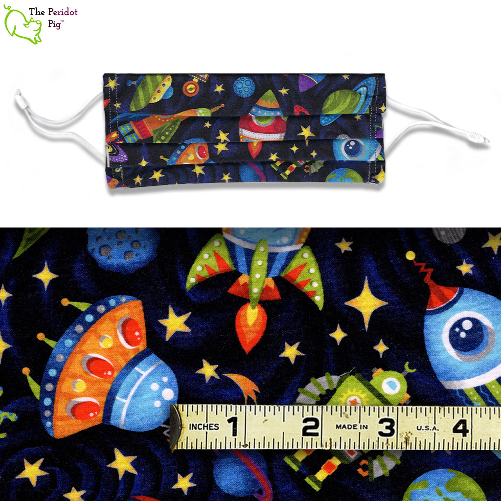 A view showing the mask and the scale of the pattern.The Launch Party fabric pattern features rockets, planets, UFOs and cranky robots on a black star filled background.