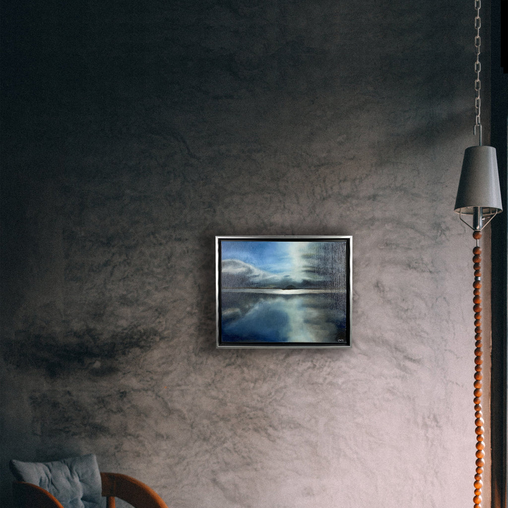 A wall mockup image of an oil painting by C. Lynn Arnold signed "LYNZ" depicting a distant island with clouds reflecting in a still lake.