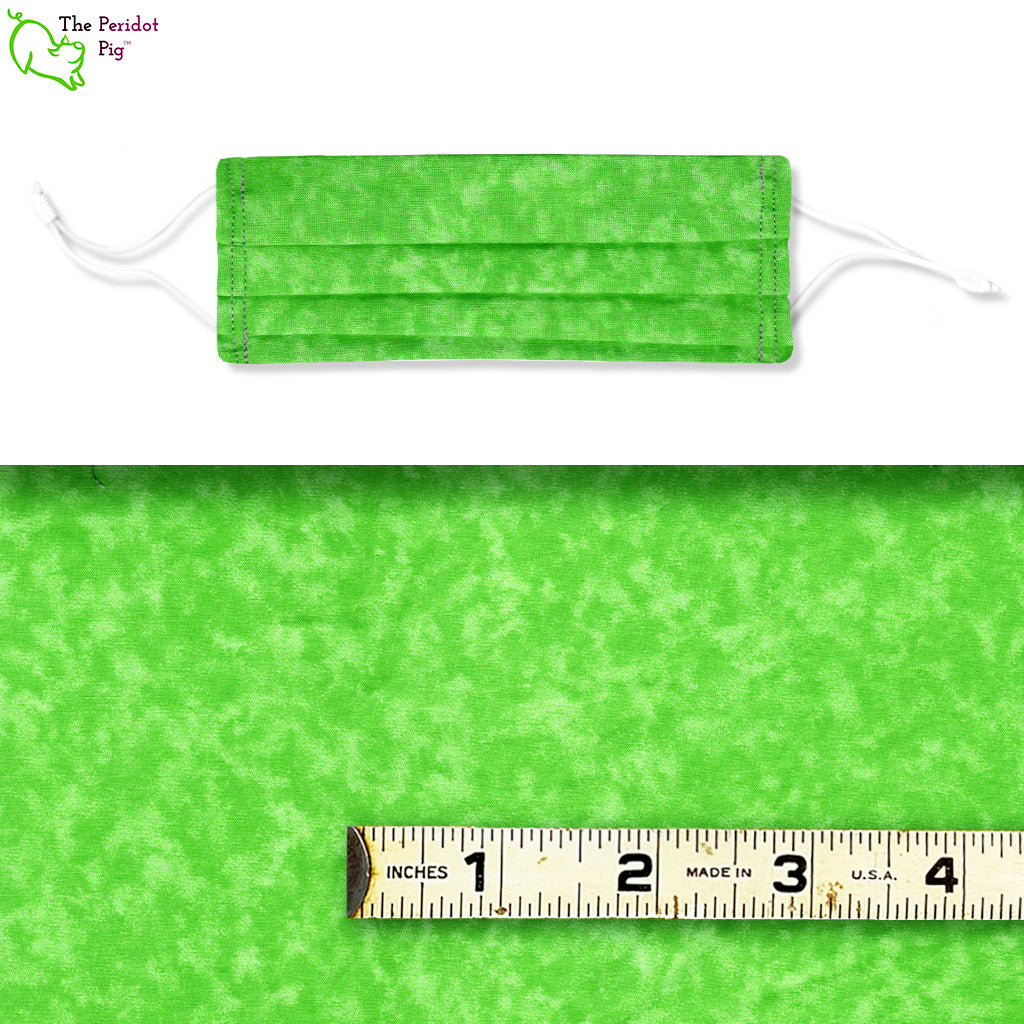 A bright kelly green fabric with swirling clouds of green. Called Green Clouds, shown with ruler.