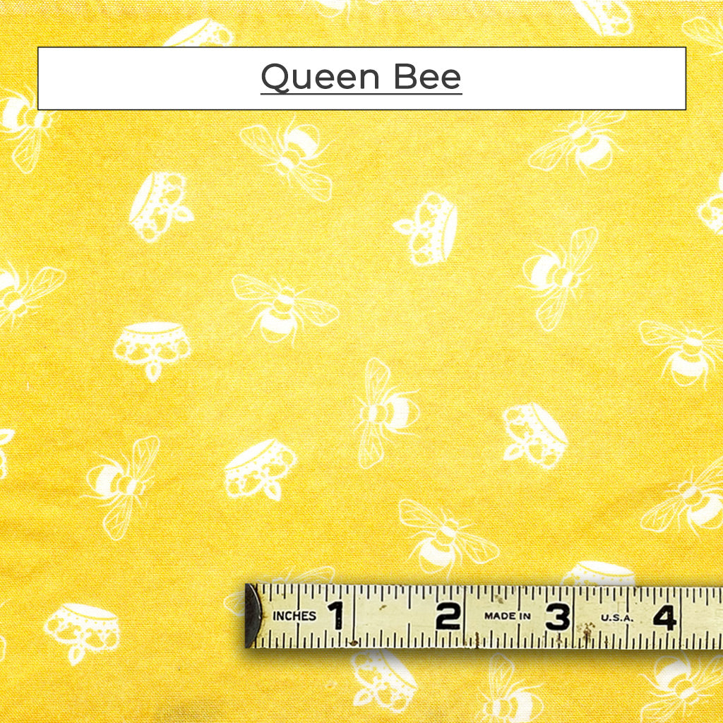 White bees and crowns on a yellow fabric background. Called Queen Bee.
