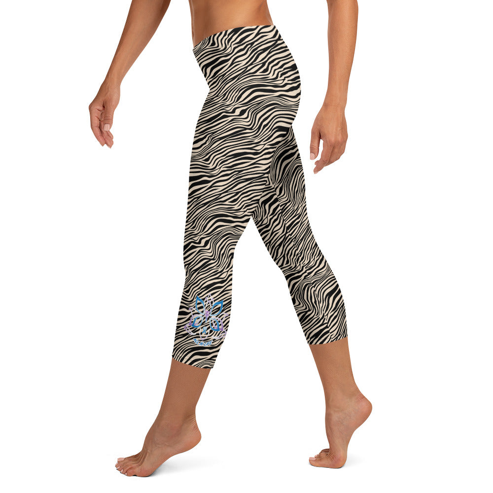Kristin Zako embodies the "Wild & Free" spirit of her print capri leggings. These are printed in vivid color with a stylized cheetah print. The words, "WILD & FREE" are down the right leg and you'll find Kristin's logo on the lower left leg. Zebra style - left view.