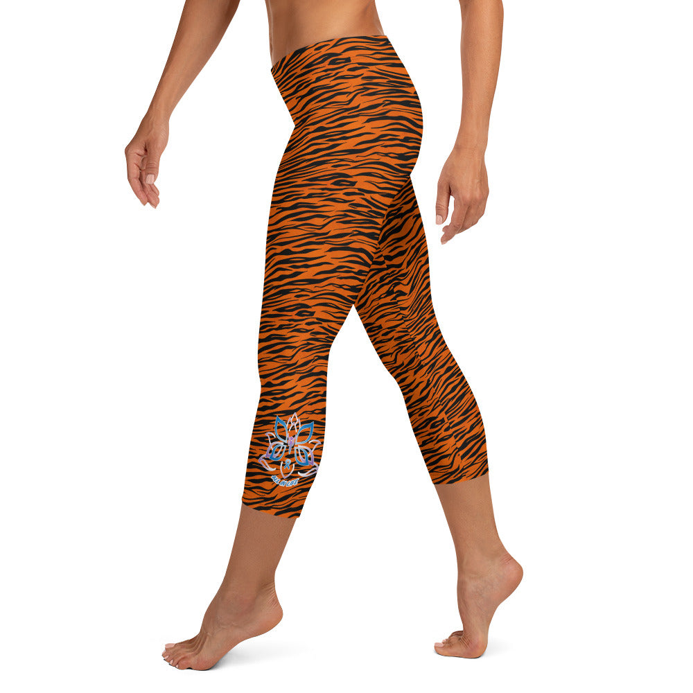 Kristin Zako embodies the "Wild & Free" spirit of her print capri leggings. These are printed in vivid color with a stylized cheetah print. The words, "WILD & FREE" are down the right leg and you'll find Kristin's logo on the lower left leg. Tiger style - left view.
