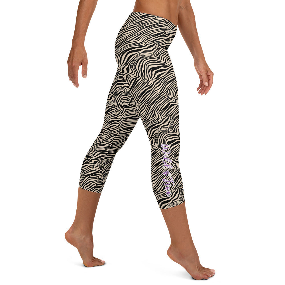 Kristin Zako embodies the "Wild & Free" spirit of her print capri leggings. These are printed in vivid color with a stylized cheetah print. The words, "WILD & FREE" are down the right leg and you'll find Kristin's logo on the lower left leg. Zebra style - Right view.