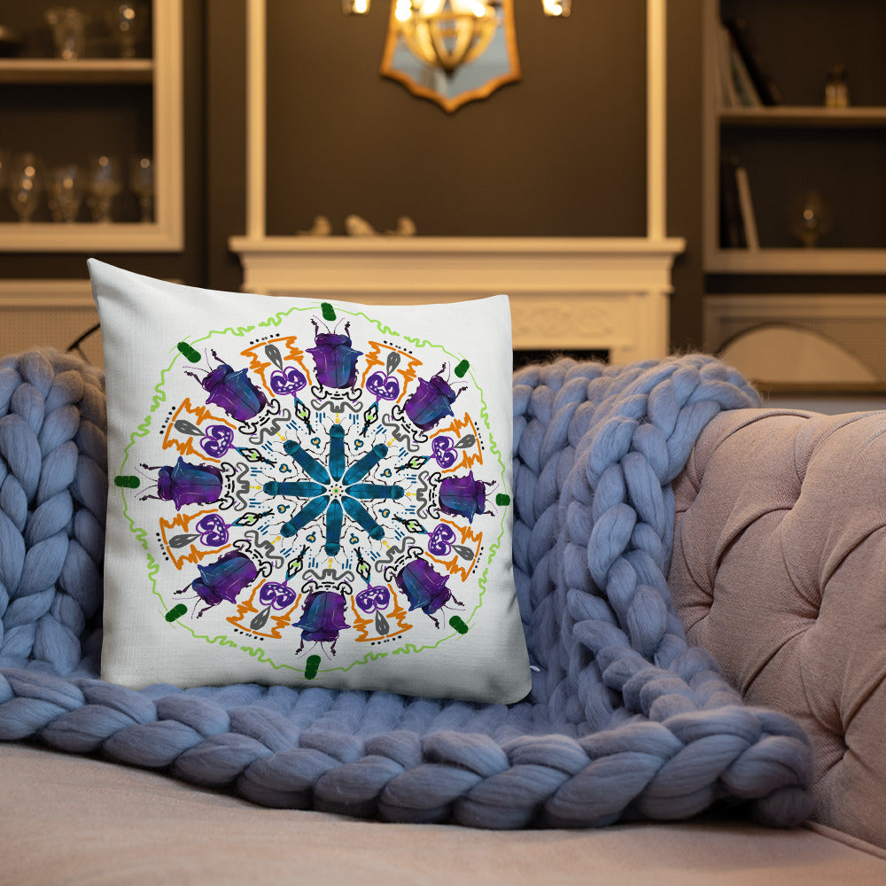 A colorful mandala of beetles graces this white pillow and is availble in either 18"x18" or 22"x22" sizes. The image is printed on both the front and back. The larger beetle has shades of violet and blue. Shown in size 18x18 on a couch.