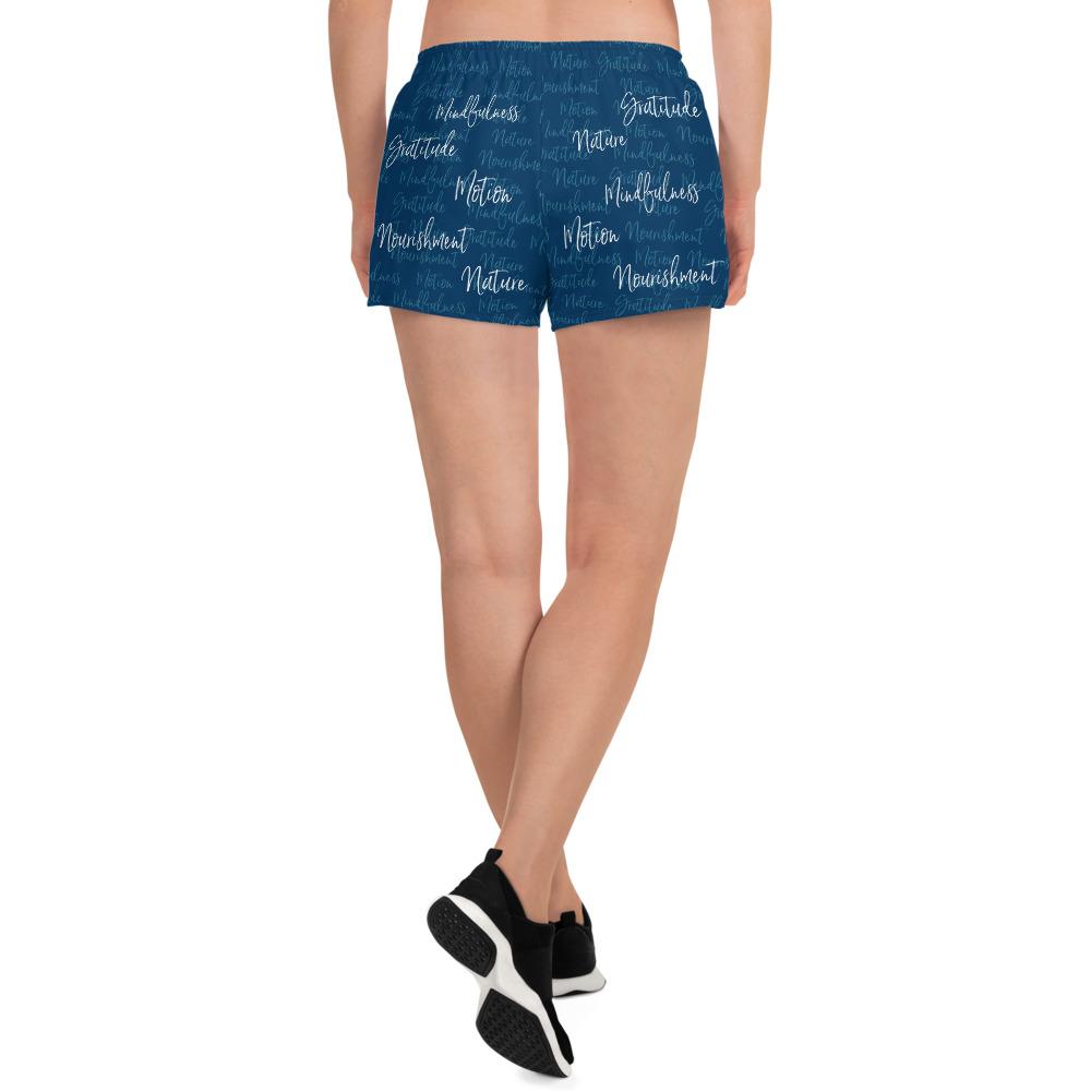 These athletic women's short shorts are so comfy and made from such a versatile fabric that you won't feel out of place at any sports event. The Kristin Zako print is filled with her four pillars phrases and topped off with her logo on the front right leg. Shown in blue. Back view.