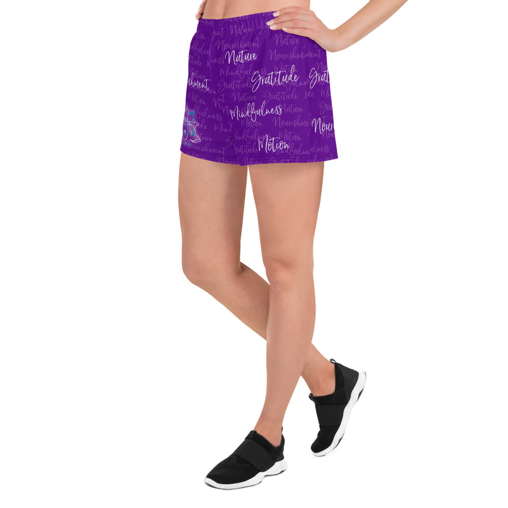 These athletic women's short shorts are so comfy and made from such a versatile fabric that you won't feel out of place at any sports event. The Kristin Zako print is filled with her four pillars phrases and topped off with her logo on the front right leg. Shown in purple. Left view.