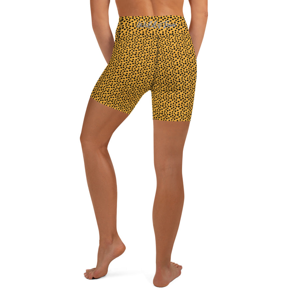 Kristin Zako embodies the "Wild & Free" spirit of her print yoga shorts. These are printed in vivid color with a stylized cheetah print.  The words, "WILD & FREE" are printed on the back waistband. Back view.