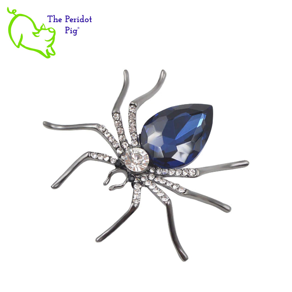 A simple and stylized spider brooch available in 3 different color options. A perfect addition to a scarf or hat. Front view in blue.